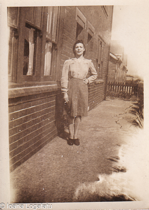 Woman in vintage dress standing by brick building