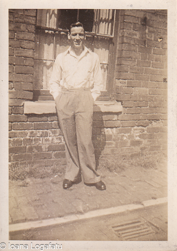 Young man poses confidently by brick wall