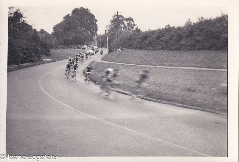 Cyclists racing around a bend on a road in summer