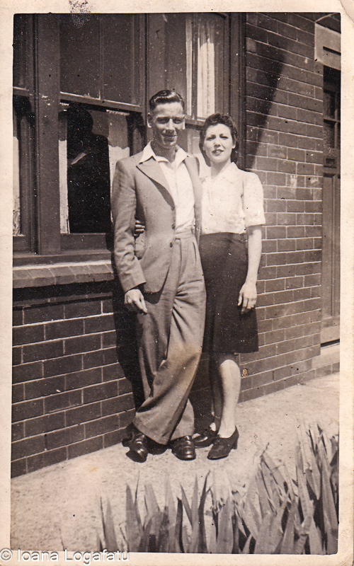Couple in a classic pose near a brick wall