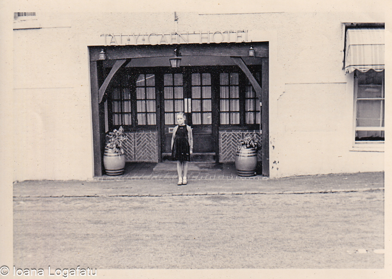 Young girl stands by an old hotel entrance