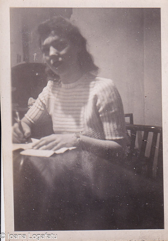 Woman writing at a rustic wooden table