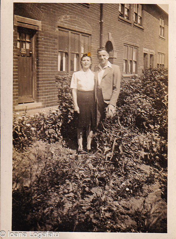 Lovers pose in a blooming garden on a sunny day