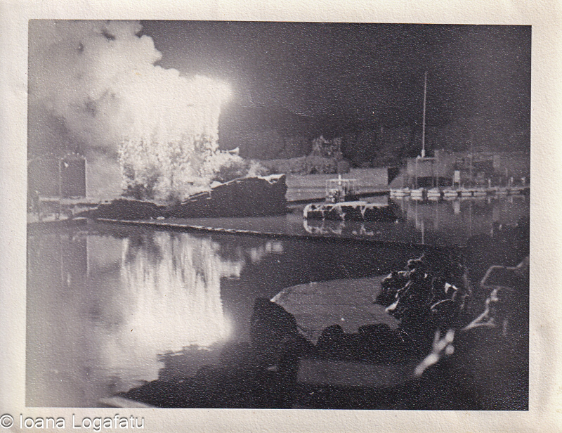 Fireworks illuminate a quiet lakeside at night
