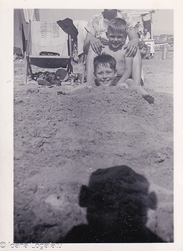 Two boys laughing together on a sunny beach day
