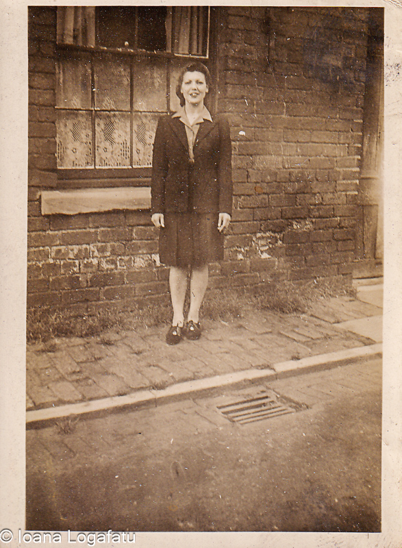 Woman stands proudly near brick wall on street