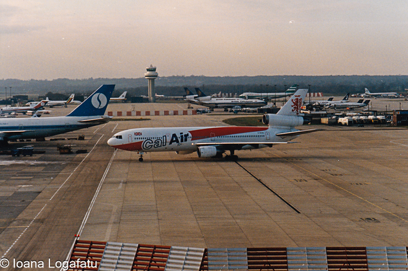 Airplane taxiing on a runway at a busy airport