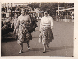 Women stroll on the sunny seaside