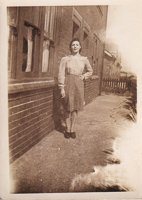 Woman in vintage dress standing by brick building