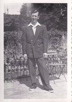 Man in stylish outfit standing near garden chair