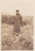 Elegant figure in winter attire amidst grass