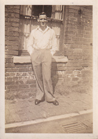 Young man poses confidently by brick wall
