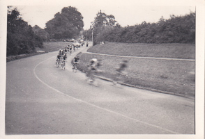 Cyclists racing around a bend on a road in summer
