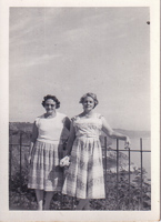 Two friends enjoy a sunny day by the coast