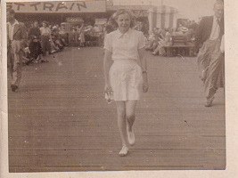 Woman walking confidently on a busy pier in summer