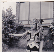 Young child in playful costume pointing outside