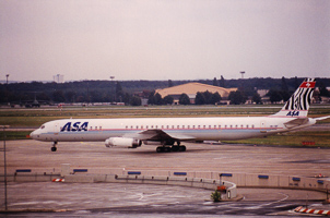 Airplane taxiing on runway near airport terminal