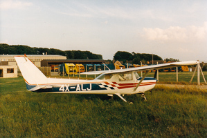 Small aircraft parked on grassy airfield at sunset