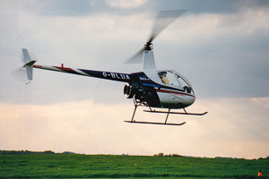 Helicopter over green fields at sunset