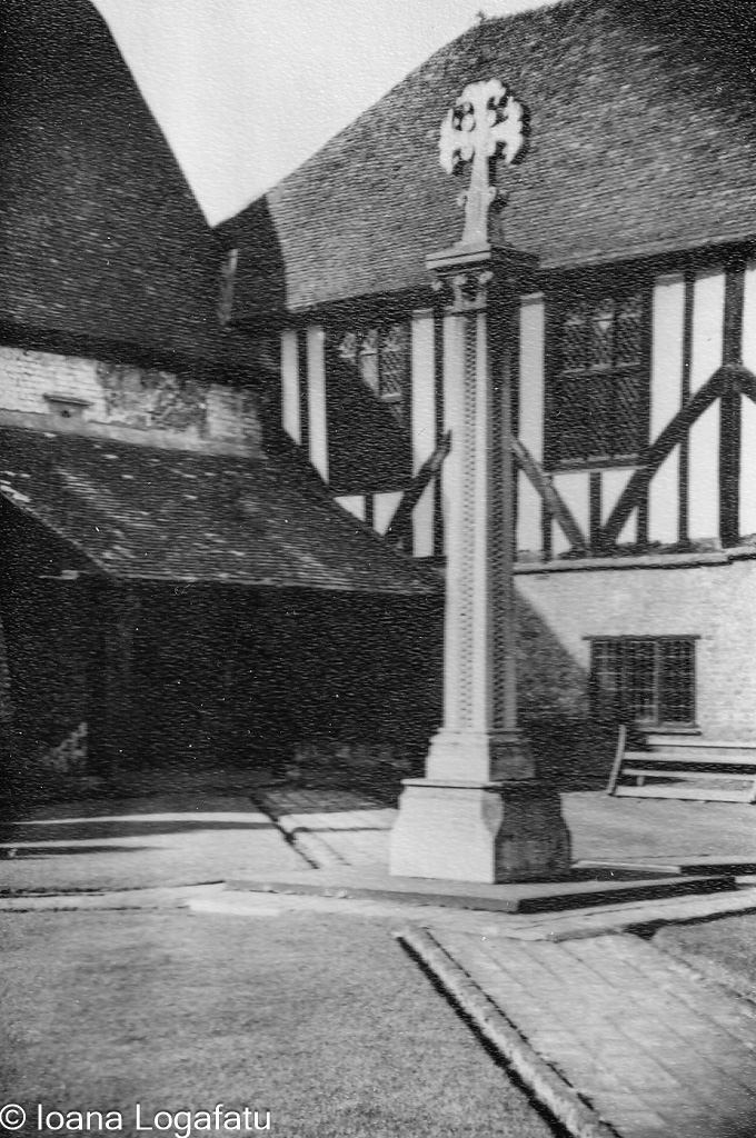 Historic cross stands in courtyard of old building