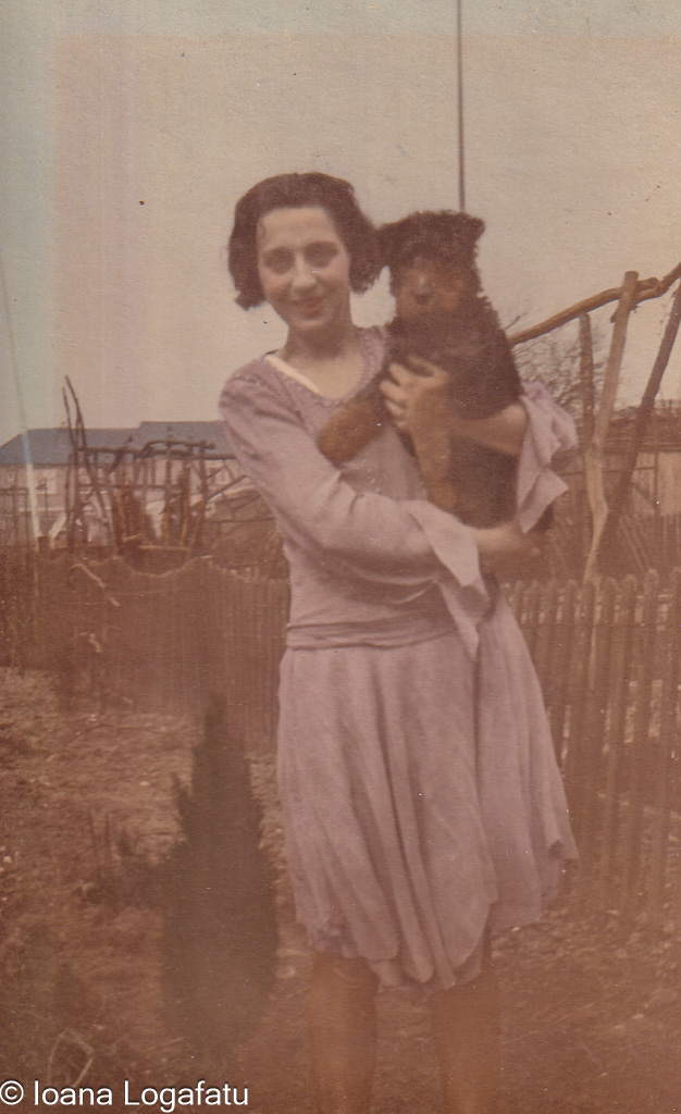 Woman holding dog in a garden from the past