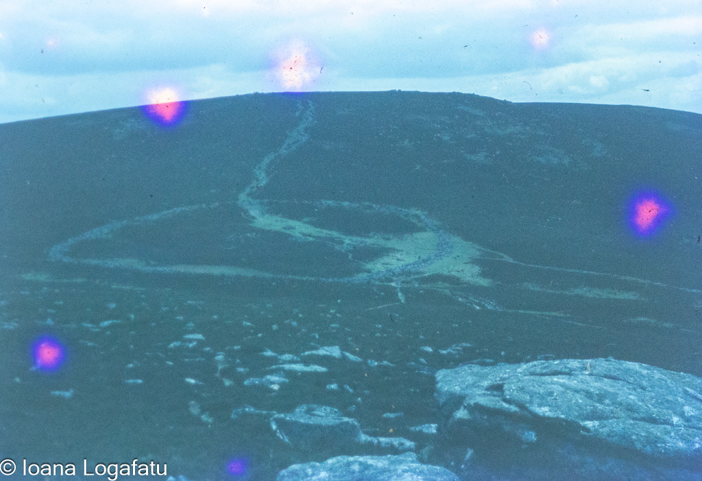 Hikers on winding trail in mountain landscape