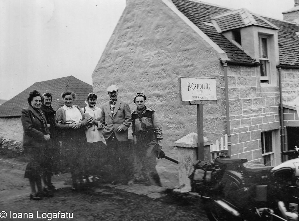 Group of travelers posing outside a cozy lodging