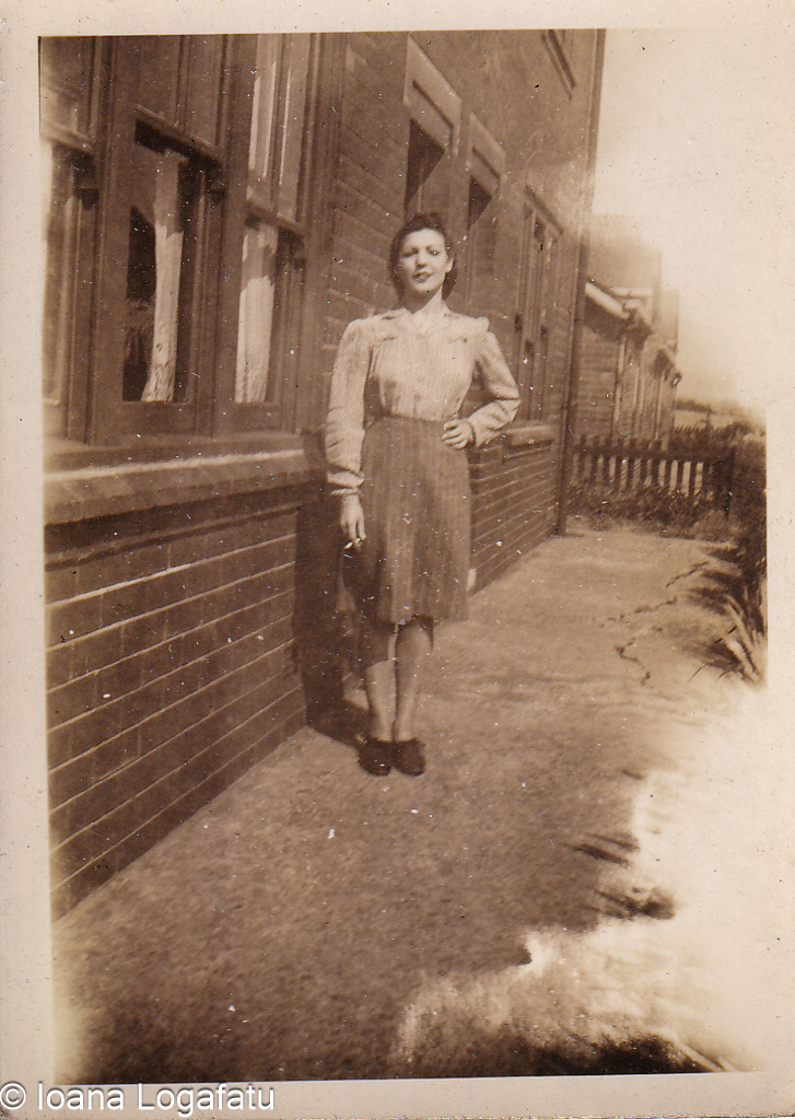 Woman in vintage dress standing by brick building