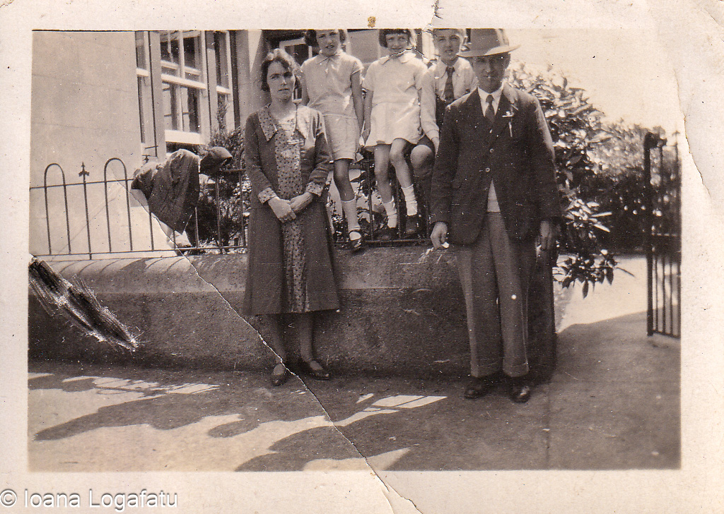 Family gathering in front of a vintage home