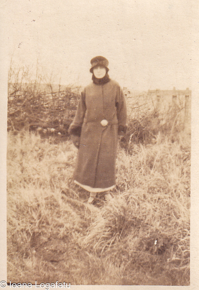 Elegant figure in winter attire amidst grass