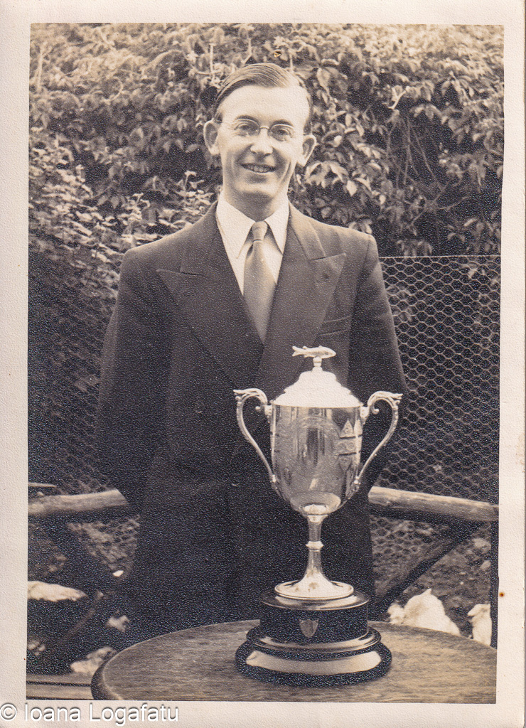 Man proudly displays a trophy in vintage setting