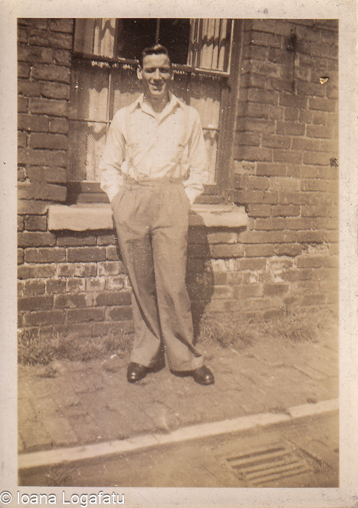 Young man poses confidently by brick wall