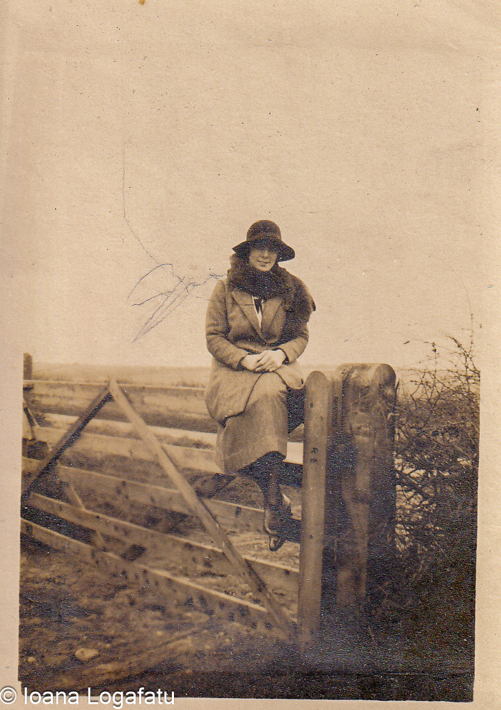 Woman sitting gracefully on a rustic gate