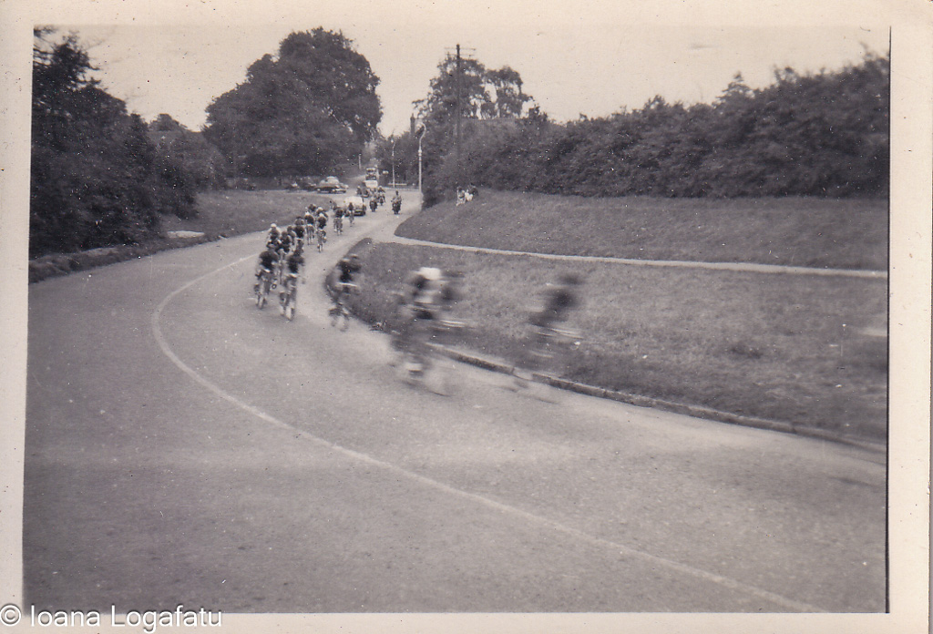 Cyclists racing around a bend on a road in summer