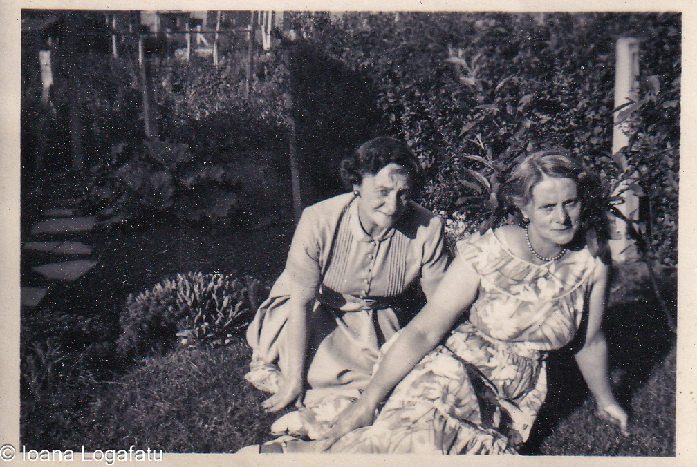 Two women enjoy a sunny day in a vibrant garden