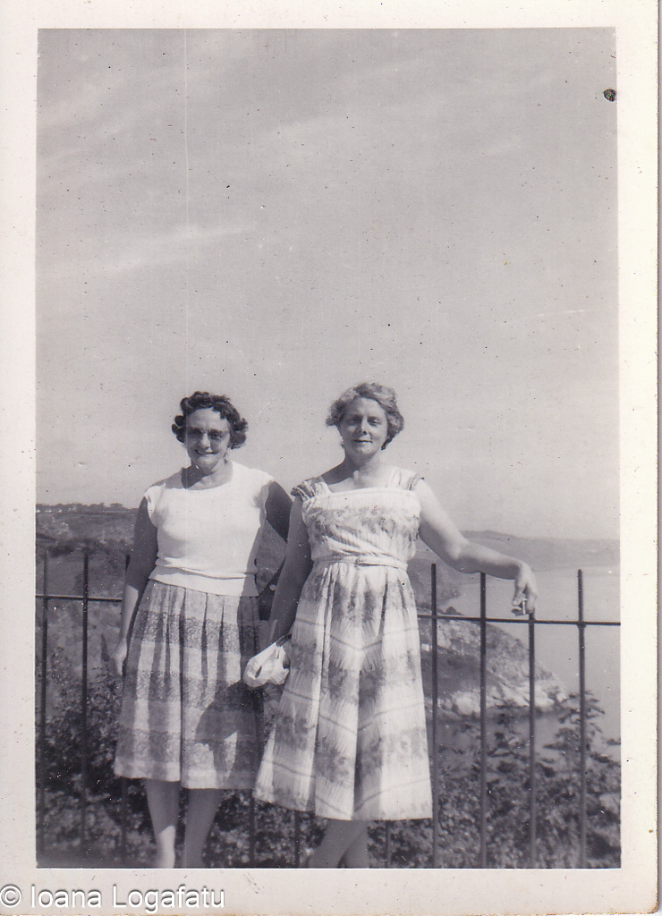 Two friends enjoy a sunny day by the coast