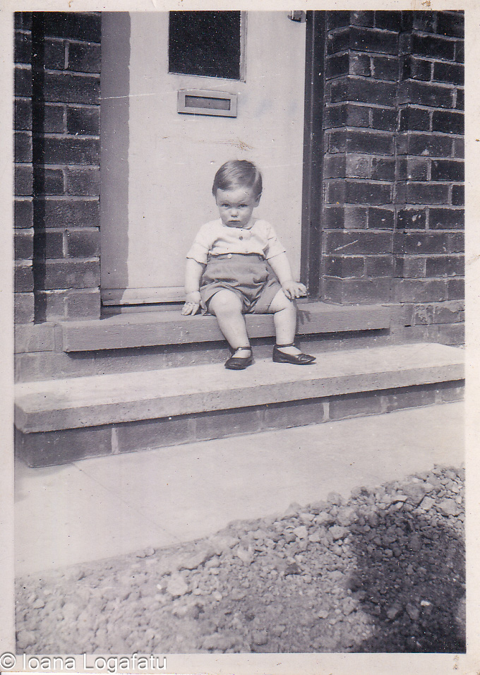 Child on porch steps, black and white