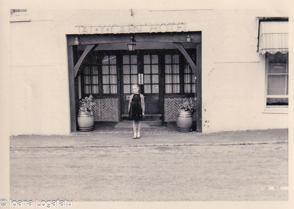 Young girl stands by an old hotel entrance