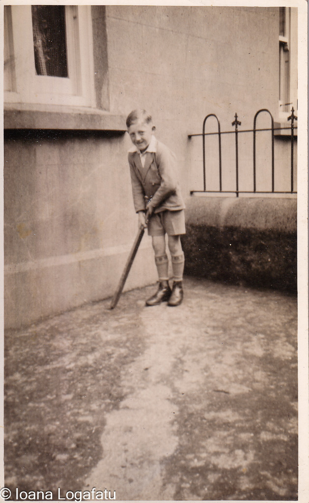 Boy happily plays cricket outside