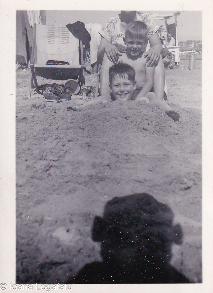 Two boys laughing together on a sunny beach day