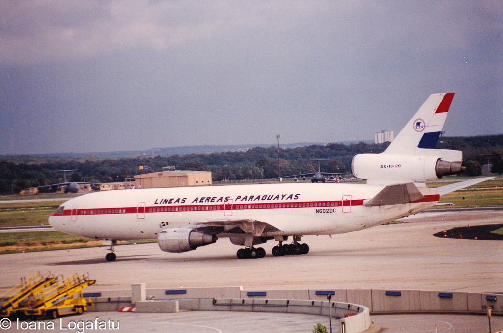 Historic aircraft in flight at a bustling airport
