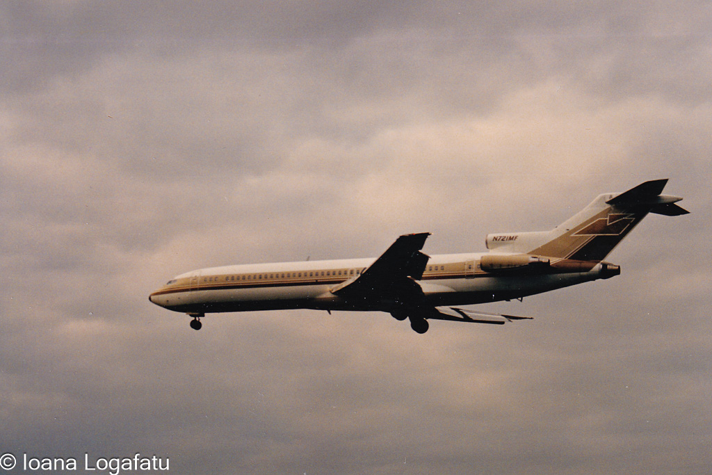 Old plane glides beneath cloudy sky