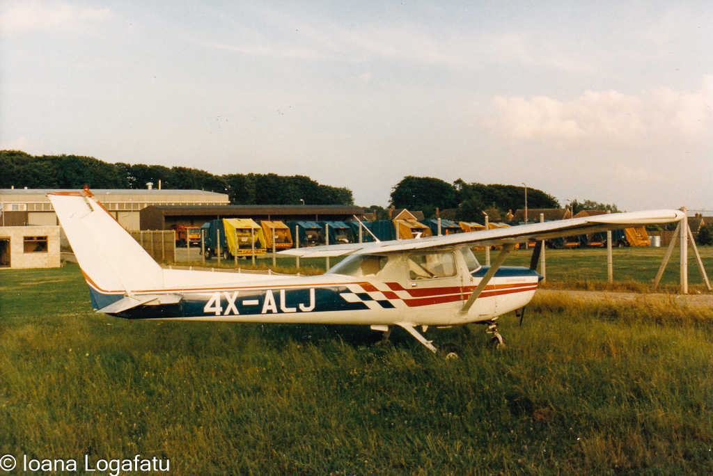 Small aircraft parked on grassy airfield at sunset