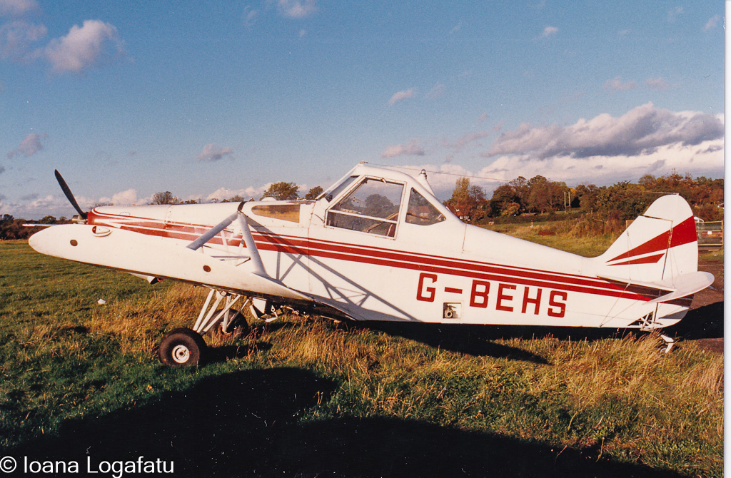 Vintage aircraft rests under a sunset sky