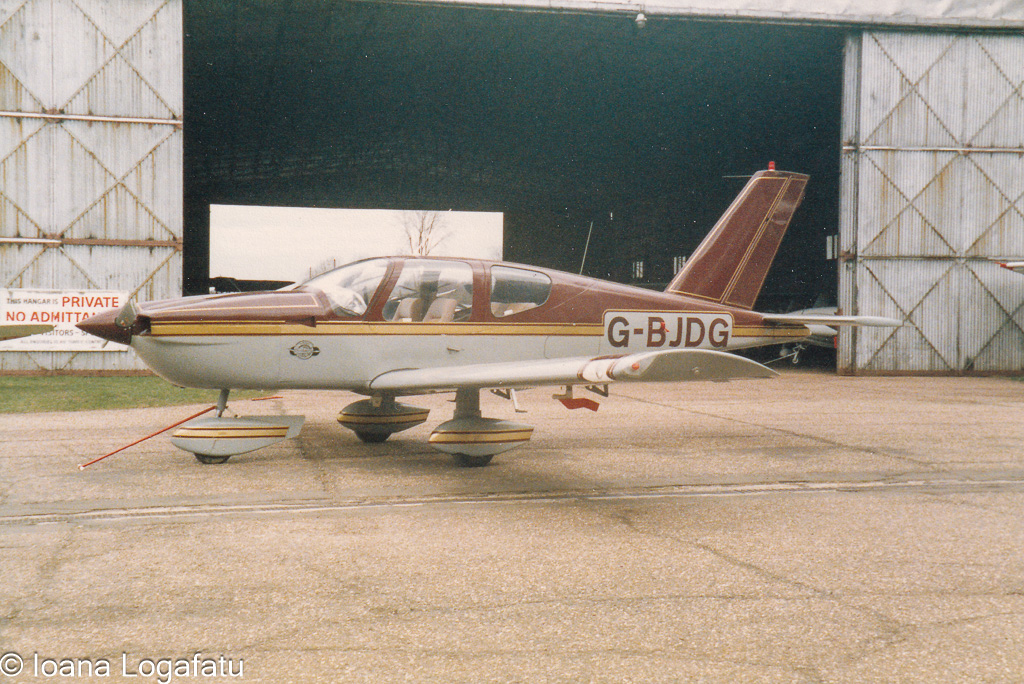 Vintage aircraft parked at an airfield hangar