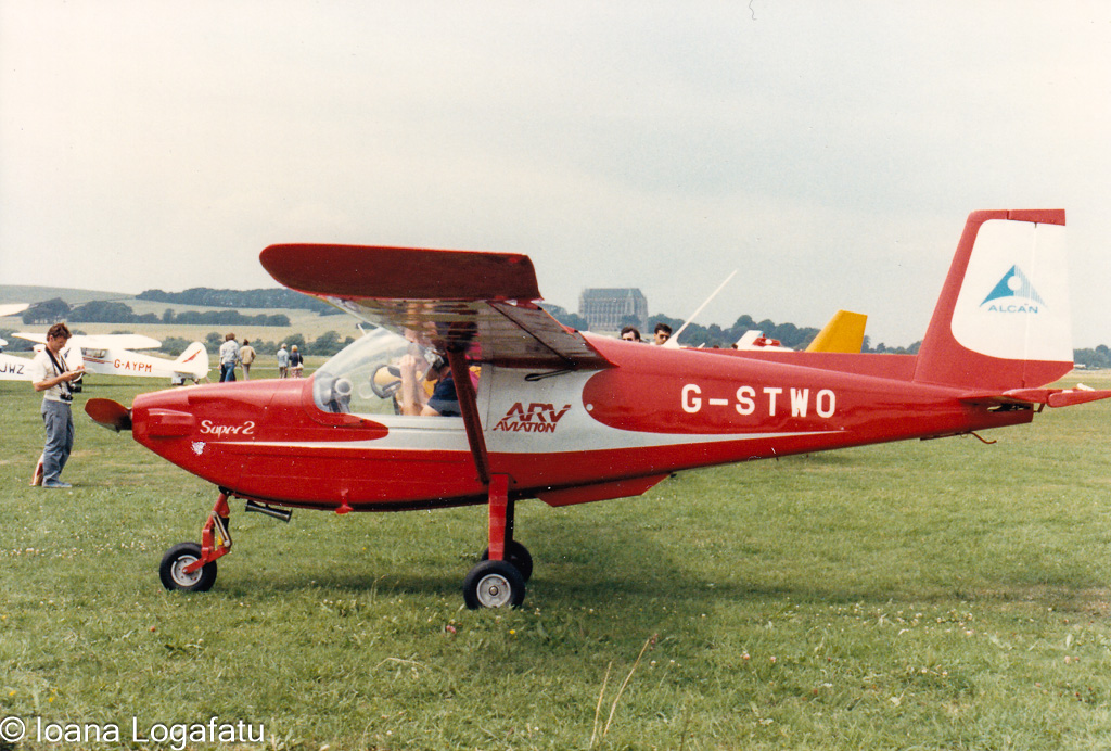 Vintage red airplane at an outdoor aviation event