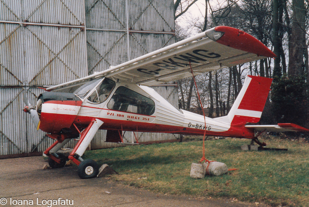 Vintage aircraft resting beside an old hangar