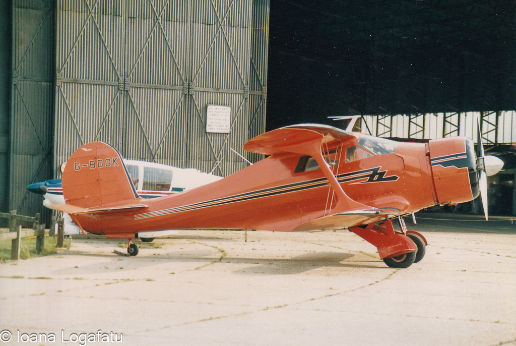 Vintage aircraft at an airfield under bright skies