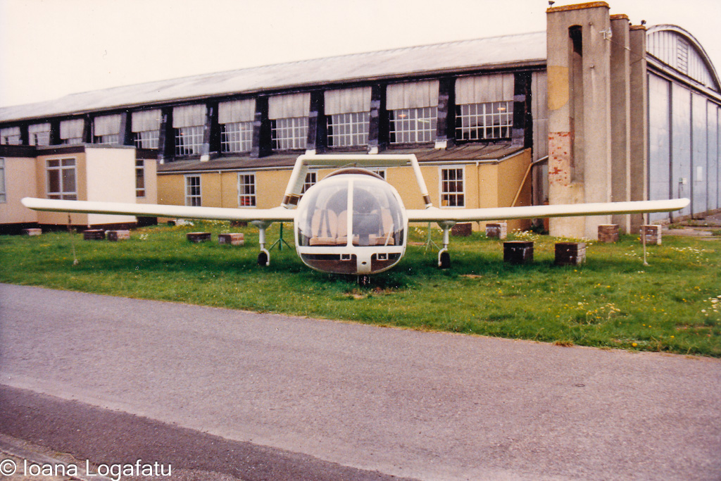 Unique aircraft displayed outside an old hangar