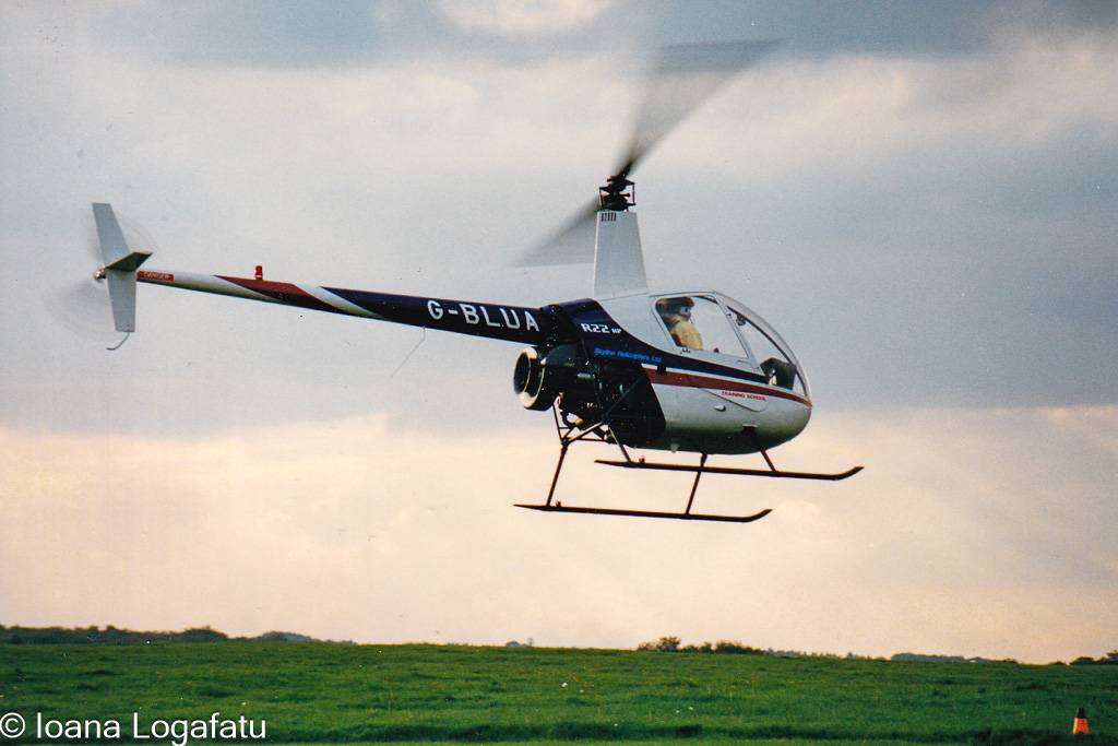 Helicopter over green fields at sunset
